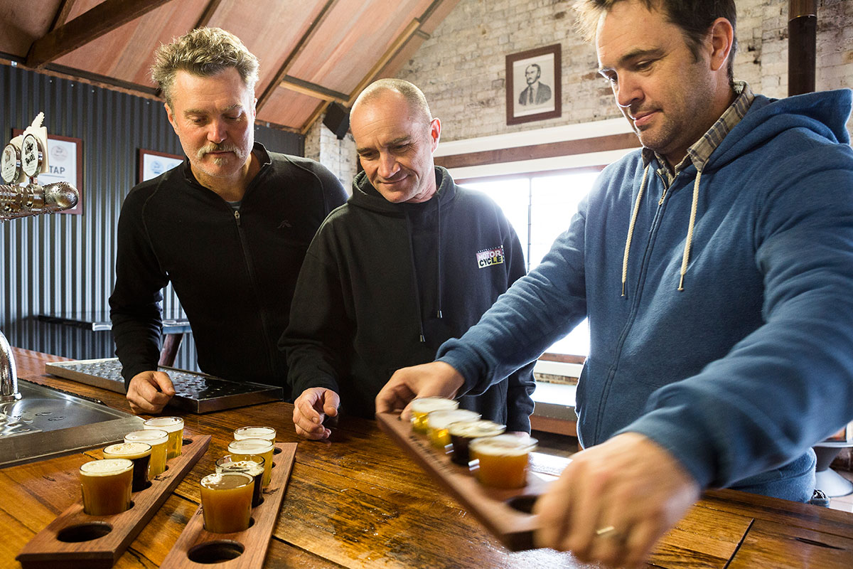 Three men taste testing beers in Uralla