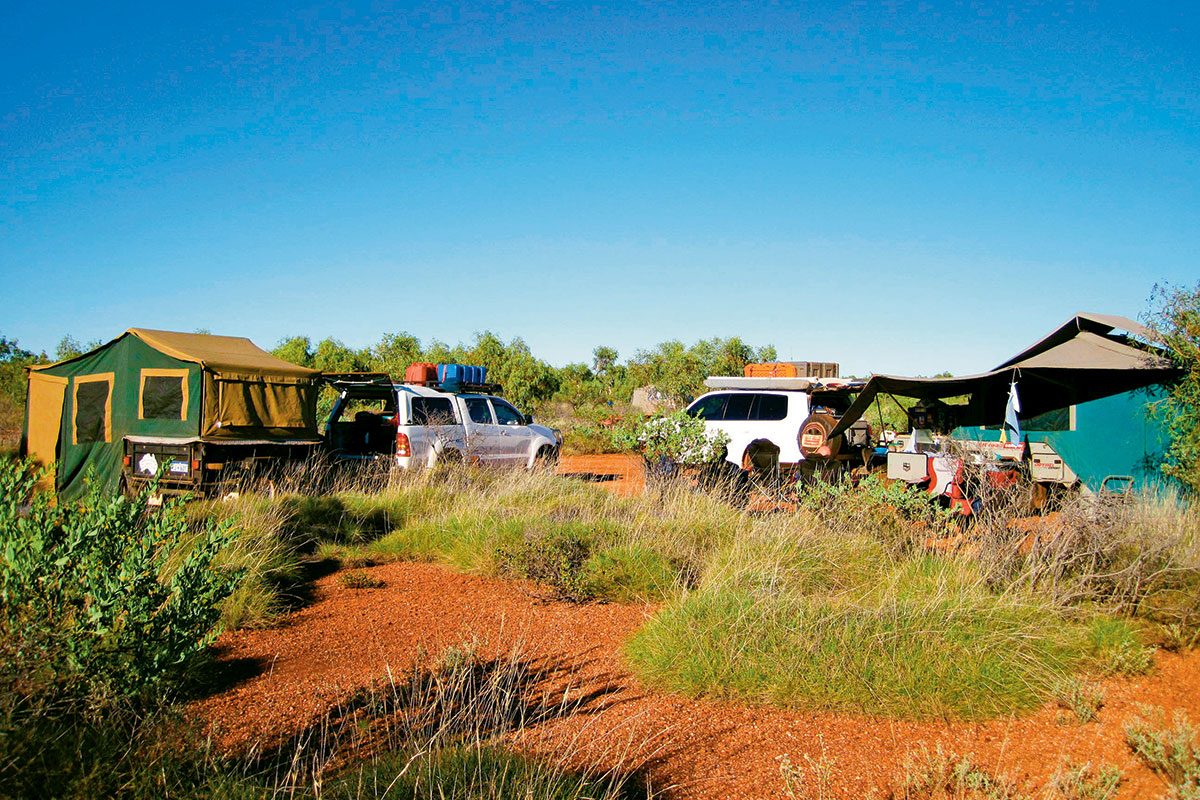 A campsite with two parked 4WD with tents
