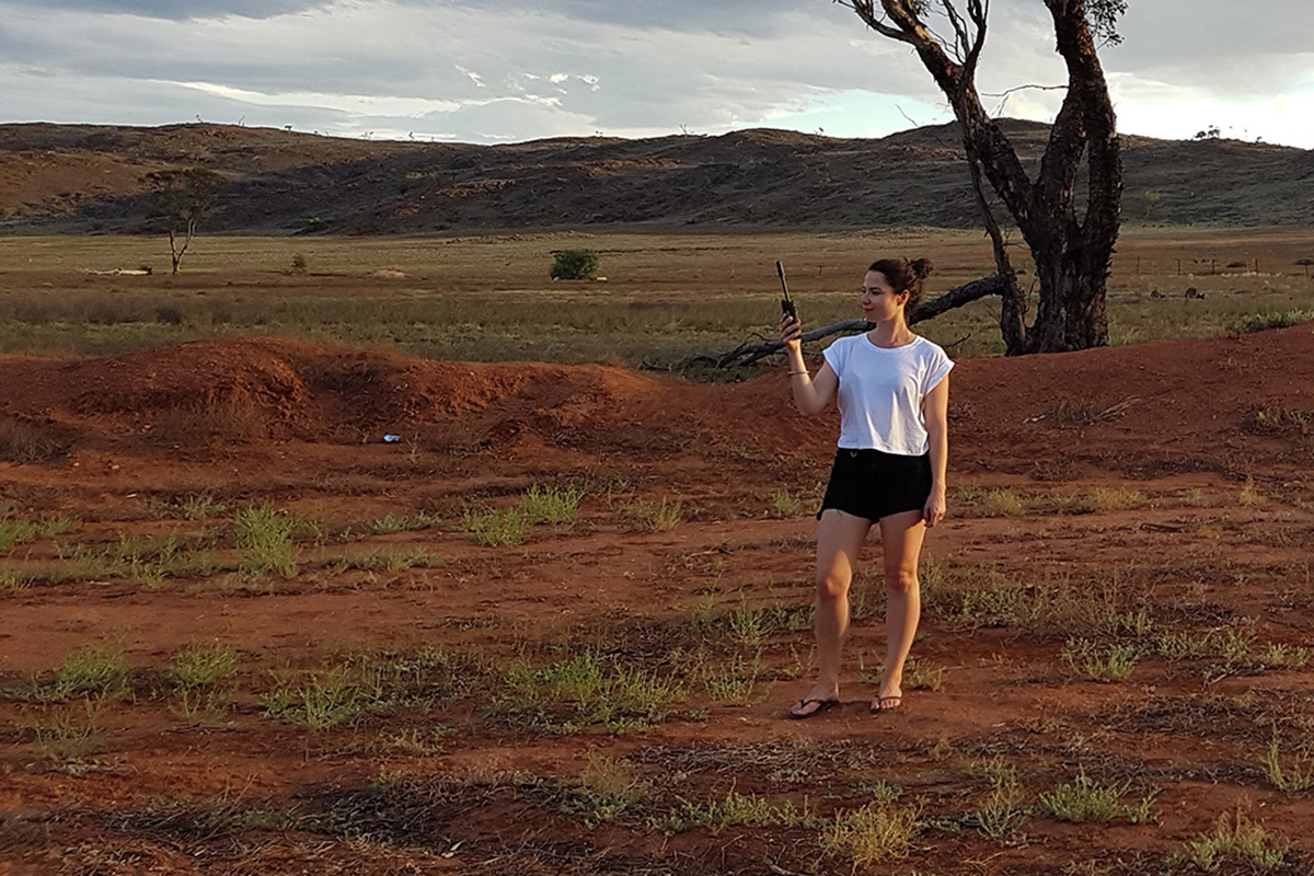 A-woman-standing-in-the-outback-holding-HEMA-HX-1-navigation-system